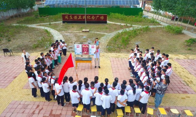 2022年7月6日,山东省聊城市,在茌平区菜屯镇阚庄村的阚庄保卫战纪念广场,阚庄保卫战亲历者王光木老人,为小员工们讲述抗战故事,展示大刀、长矛。